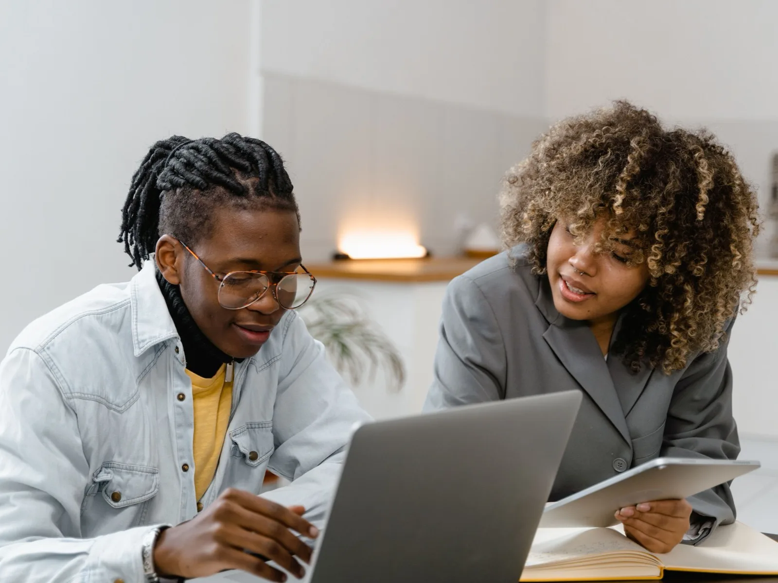 Two colleagues looking at a laptop together at a desk