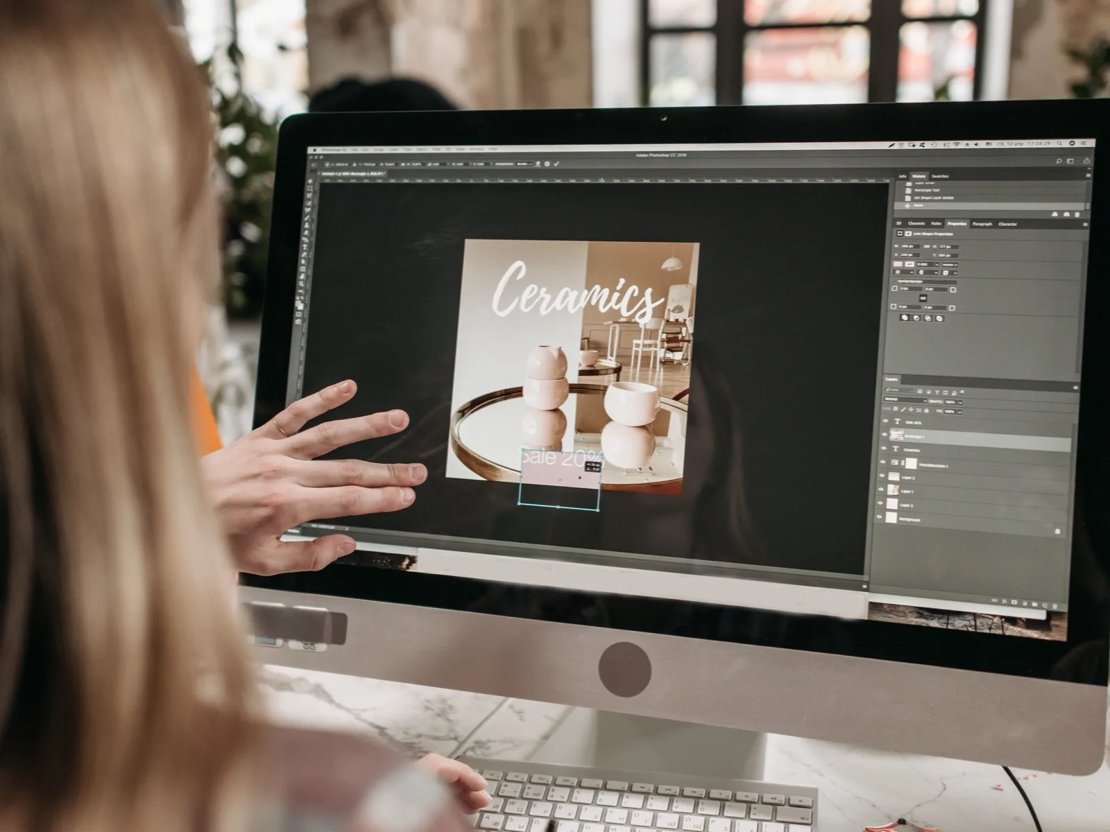 A designer building a product layout in image editing software on a desktop computer